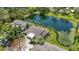 Aerial view showcasing house by serene pond, lush greenery, mature trees, and surrounding neighborhood at 7926 Woodpointe Ct # 29, Sarasota, FL 34238