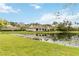Backyard view of community pond with residences in the background and lily pads in the water at 7926 Woodpointe Ct # 29, Sarasota, FL 34238