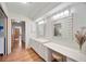 Bright bathroom featuring double mirrors, white cabinetry, and a vanity area at 7926 Woodpointe Ct # 29, Sarasota, FL 34238