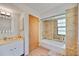 Bright bathroom with vanity and tub, showcasing tile work and natural light from a window at 7926 Woodpointe Ct # 29, Sarasota, FL 34238