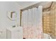 Bathroom with a vanity sink and shower with tile surround and floral shower curtain at 7926 Woodpointe Ct # 29, Sarasota, FL 34238