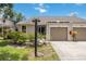 Inviting home exterior with attached garage, professional landscaping with flowering shrubs, and lush green lawn at 7926 Woodpointe Ct # 29, Sarasota, FL 34238