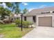 Charming home exterior featuring verdant lawn with flowering shrubs, mature trees and a private garage at 7926 Woodpointe Ct # 29, Sarasota, FL 34238