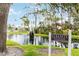 Community pond featuring a decorative fountain, lush landscaping, and a sign marking the Serenity Fountain at 7926 Woodpointe Ct # 29, Sarasota, FL 34238