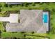 An aerial view of a home with a private screened-in pool, and a detailed roofline at 8218 Genoa Blvd, Lakewood Ranch, FL 34202