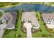 Aerial view of a home with a three-car garage and stone driveway near the lake at 8218 Genoa Blvd, Lakewood Ranch, FL 34202