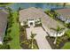 Overhead view of a house with a three-car garage, stone driveway, and beautiful landscaping near a pond at 8218 Genoa Blvd, Lakewood Ranch, FL 34202