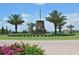Beautifully landscaped roundabout with a stone monument, surrounded by lush greenery and palm trees at 8218 Genoa Blvd, Lakewood Ranch, FL 34202