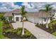 Beautiful home exterior with a large driveway, three-car garage, and professional landscaping with palm trees at 8218 Genoa Blvd, Lakewood Ranch, FL 34202
