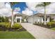 Elegant two-story home with a paved driveway, lush landscaping, and a three-car garage at 8218 Genoa Blvd, Lakewood Ranch, FL 34202