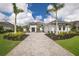 Elegant two-story home with a paved driveway, lush landscaping, and a three-car garage at 8218 Genoa Blvd, Lakewood Ranch, FL 34202