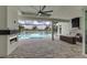 Large outdoor living area with a fireplace, outdoor kitchen and relaxing pool with lake views at 8218 Genoa Blvd, Lakewood Ranch, FL 34202