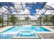 Stunning pool area with a spa and a waterfall overlooking a large serene lake at 8218 Genoa Blvd, Lakewood Ranch, FL 34202