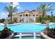An inviting swimming pool with fountains, palm trees, and elegant statues with the clubhouse in the background at 8218 Genoa Blvd, Lakewood Ranch, FL 34202