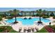 A luxurious swimming pool with water features, palm trees, lounge chairs, and scenic lake views at 8218 Genoa Blvd, Lakewood Ranch, FL 34202