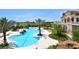 A luxurious swimming pool surrounded by palm trees, lush landscaping, and comfortable lounge chairs for relaxation at 8218 Genoa Blvd, Lakewood Ranch, FL 34202