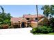 Charming two-story home featuring a lush landscaped yard, circular driveway, and a welcoming front entrance at 9102 12Th Nw Ave, Bradenton, FL 34209