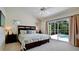 Light filled main bedroom with vaulted ceilings, view to pool, and a dark wood king bed at 9102 12Th Nw Ave, Bradenton, FL 34209