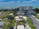 Drone shot showing beachfront condos, residential areas, and manicured lawns, set against an ocean backdrop at 101 Whispering Sands Dr # 307, Sarasota, FL 34242