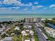 Wide-angle shot showcases beachfront apartments, cozy homes, and ample parking, against sea view at 101 Whispering Sands Dr # 307, Sarasota, FL 34242