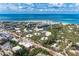 Stunning aerial view of a coastal community with homes, a small lake, and the ocean in the background at 101 Whispering Sands Dr # 307, Sarasota, FL 34242