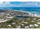 Expansive aerial view showcasing beachfront properties, a tranquil pond, and lush green landscapes at 101 Whispering Sands Dr # 307, Sarasota, FL 34242