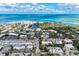 Beautiful aerial view of a coastal town featuring beachfront condos and tropical trees at 101 Whispering Sands Dr # 307, Sarasota, FL 34242