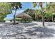 Community beach area with picnic tables, tiki hut, and BBQ grills for resident use at 101 Whispering Sands Dr # 307, Sarasota, FL 34242
