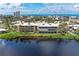 Waterfront condo complex featuring palm trees, lush greenery, and stunning water views at 101 Whispering Sands Dr # 307, Sarasota, FL 34242