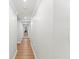 Clean hallway featuring hardwood floors, white walls, and decorative molding at 101 Whispering Sands Dr # 307, Sarasota, FL 34242