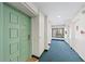 Hallway leading to unit, featuring neutral walls, blue carpet, and an exterior view at 101 Whispering Sands Dr # 307, Sarasota, FL 34242