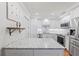 Well-lit kitchen boasts stainless steel appliances, sleek white cabinetry, and a beautiful marbled countertop island at 101 Whispering Sands Dr # 307, Sarasota, FL 34242