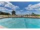 Relaxing community pool with beach views, lounge chairs, and a clear blue sky at 101 Whispering Sands Dr # 307, Sarasota, FL 34242