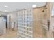 Bathroom featuring a tiled shower, towel racks, and glass block wall at 105 Inlets Blvd # 105, Nokomis, FL 34275