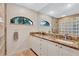 Bathroom featuring double sinks, granite countertops, and large mirror at 105 Inlets Blvd # 105, Nokomis, FL 34275