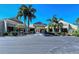 Inviting clubhouse entrance featuring tropical landscaping, covered entry, and convenient bicycle parking at 105 Inlets Blvd # 105, Nokomis, FL 34275