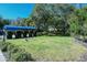 Open lawn area with manicured landscaping for community use, featuring horseshoe pits and shady trees at 105 Inlets Blvd # 105, Nokomis, FL 34275
