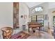 Bright living room featuring a beautiful piano, stylish decor, and an elegant window with natural light at 105 Inlets Blvd # 105, Nokomis, FL 34275