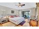 Bright bedroom with hardwood floors, slider to pool area, and ensuite bathroom at 105 Inlets Blvd # 105, Nokomis, FL 34275