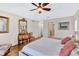Bedroom featuring a large bed, ensuite bath, and decorative mirror at 105 Inlets Blvd # 105, Nokomis, FL 34275