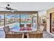 Enclosed patio featuring an outdoor dining set and peaceful views of the pool area at 105 Inlets Blvd # 105, Nokomis, FL 34275