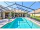 Relaxing pool area with a screened enclosure, landscaped surroundings, and ample patio space at 105 Inlets Blvd # 105, Nokomis, FL 34275