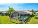 Aerial view of a screened-in pool surrounded by lush, landscaped grounds and a privacy wall at 105 Inlets Blvd # 105, Nokomis, FL 34275
