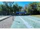 Community shuffleboard court ready for gameplay, featuring shade structure and bench seating at 105 Inlets Blvd # 105, Nokomis, FL 34275