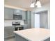 Modern kitchen with gray cabinets, stainless steel appliances, white countertops, and a center island at 115 41St Ne Ave, St Petersburg, FL 33703
