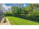 Green backyard featuring a dark metal fence lined with flower boxes, enhancing the outdoor space at 11625 Parrotfish St, Venice, FL 34292