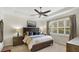 Comfortable bedroom with a ceiling fan, large window, and neutral decor, perfect for relaxation at 11625 Parrotfish St, Venice, FL 34292