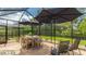 Covered patio with table and chairs, lush landscaping, and a peaceful outdoor setting with two large umbrellas at 11625 Parrotfish St, Venice, FL 34292