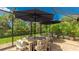 Covered patio with table and chairs, perfect for outdoor dining and entertaining with two large umbrellas at 11625 Parrotfish St, Venice, FL 34292