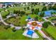 Aerial view of community park, showcasing green spaces, playground, and splash pad areas at 12031 Longview Lake Cir, Lakewood Ranch, FL 34211